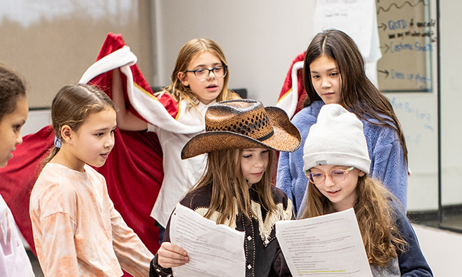  Many young girls on stage performing and posing. 